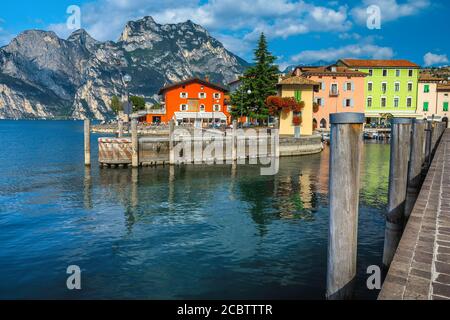 Bunte Gebäude am Ufer des Gardasees. Kleiner Hafen mit Fischerbooten, Torbole, Gardasee, Italien, Europa Stockfoto