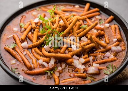 SEV Bhaji oder Shev Sabji oder Kathiyavadi Dhaba Style Gathiya nu shaak - würziges, süßes und würziges Tomatencurry mit knackigem Ganthia oder Gathia Stockfoto