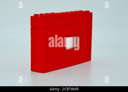 Rote Backstein Kunststoff Lego Wand mit einem Fenster im Studio Aufnahme isoliert auf weißem Hintergrund Stockfoto