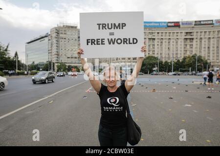 Bukarest, Rumänien - 10. August 2020: Während einer politischen Kundgebung zeigen die Menschen Qanon-Botschaften auf Kartons. Stockfoto