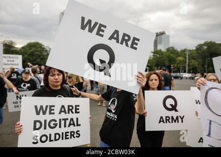 Bukarest, Rumänien - 10. August 2020: Während einer politischen Kundgebung zeigen die Menschen Qanon-Botschaften auf Kartons. Stockfoto