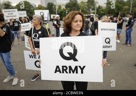 Bukarest, Rumänien - 10. August 2020: Während einer politischen Kundgebung zeigen die Menschen Qanon-Botschaften auf Kartons. Stockfoto