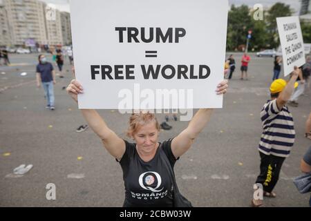 Bukarest, Rumänien - 10. August 2020: Während einer politischen Kundgebung zeigen die Menschen Qanon-Botschaften auf Kartons. Stockfoto