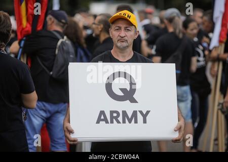 Bukarest, Rumänien - 10. August 2020: Während einer politischen Kundgebung zeigen die Menschen Qanon-Botschaften auf Kartons. Stockfoto