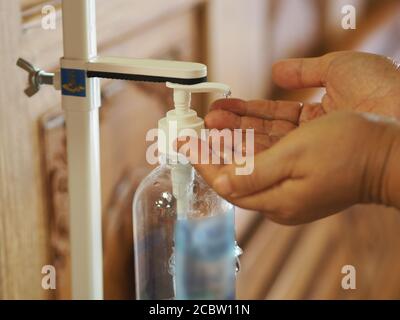 Frau verwendet Hand Sanitizer, Gel alkoholische Mischung mit Gelatine in klaren Plastikflasche mit Pumpe schieben Reinigung schmutzig zu verhindern Keime schützen Cont Stockfoto