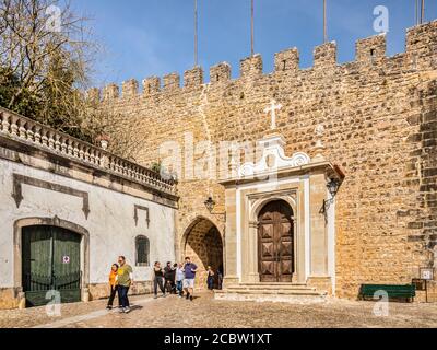 11. März 2020: Obidos, Portugal - Besucher, die durch das Haupttor in der ummauerten Stadt Obidos, Portugal, gehen. Stockfoto