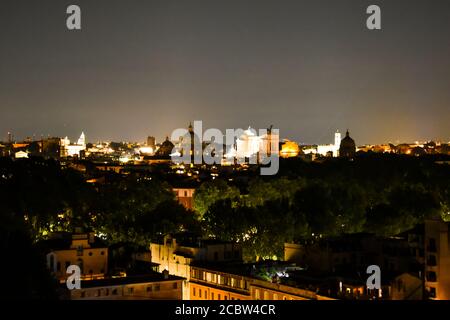 Rom bei Nacht mit der Kuppel des Petersdoms und der Piazza Venezia in der Ferne Stockfoto