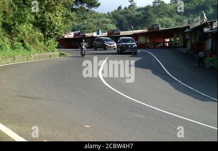 Bogor, Indonesien - 23. Mai 2019: Eine ländliche Kurvenstraße in Cisarua, Bogor, West Java, Indonesien. Stockfoto