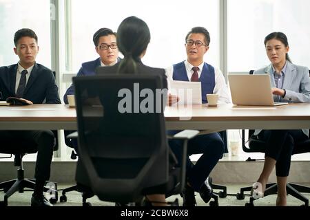 Junge asiatische Geschäftsfrau wird von einer Gruppe von interviewt HR-Führungskräfte des Unternehmens