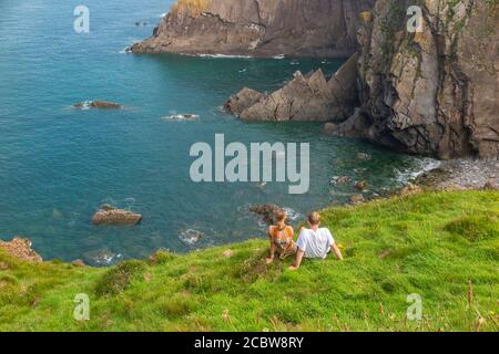 Ein Paar genießt die schöne Aussicht auf Baggy Point in North Devon, England, Vereinigtes Königreich Stockfoto