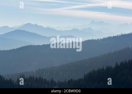 Geschichtete alpine Bergkette mit schönem Wetter und Nebel in Filzmoos, Kreis Salzburg, Österreich Stockfoto
