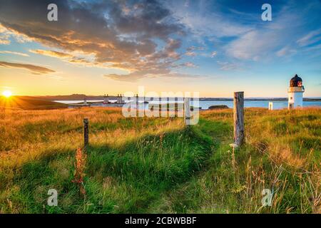 Wunderschöner Sonnenuntergang über dem Leuchtturm und den Küstenschutzhütten in Arnish Punkt in der Nähe von Stornoway auf der Isle of Lewis in der Äußere Hebriden von Schottland Stockfoto