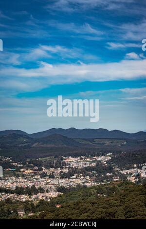 Stadtansicht mit Bergkette und hellblauen Himmel von der Hügelspitze am Tag Bild wird von doddabetta Gipfel ooty indien genommen. Es zeigt die Vogelperspektive Stockfoto