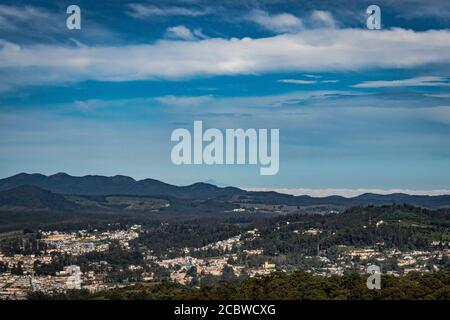 Stadtansicht mit Bergkette und hellblauen Himmel von der Hügelspitze am Tag Bild wird von doddabetta Gipfel ooty indien genommen. Es zeigt die Vogelperspektive Stockfoto