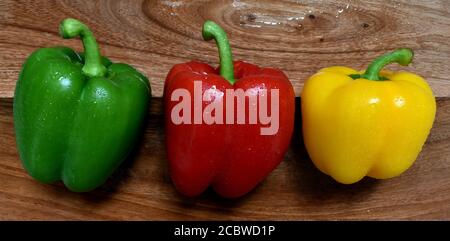 Paprika süße Glocke, gemischt Rot, grün gelbe Farben, frisch gewaschen, nass, Nahaufnahme, perfekte Haut, verlockende Bild von oben auf Holz Chop Board. Stockfoto