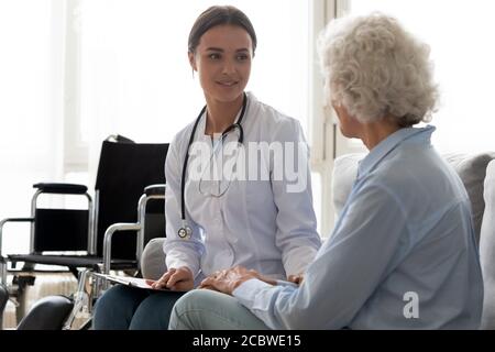 Junge Ärztin besucht behinderte ältere ältere ältere Patienten. Stockfoto
