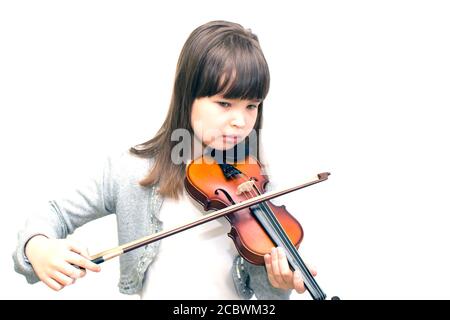 Das Kind spielt nachdenklich Geige. Stockfoto