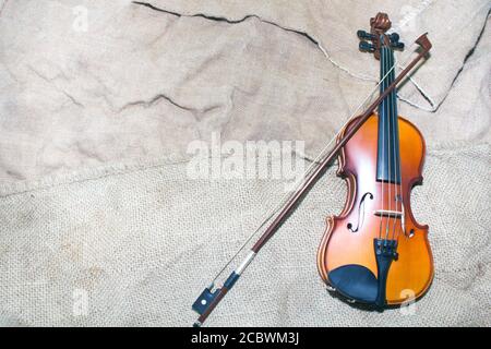 Schöne Geige ruht auf einem alten Stück Material. Stockfoto