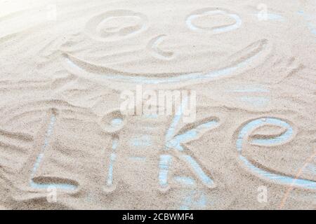 Handgeschriebenes Wort WIE auf braunem Sand am Strand an sonnigen Tagen. Stockfoto