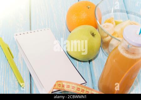 Diät, gesunde und aktive Lifestyle-Konzept, Äpfel, Bananen, gehen, Maßband, Saftflasche, leere Notizblock Draufsicht mit leerem Kopierraum. Stockfoto