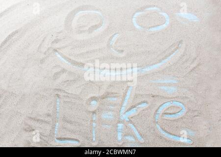 Handgeschriebenes Wort WIE auf braunem Sand am Strand an sonnigen Tagen. Stockfoto