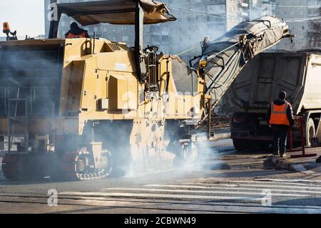 Traktor, Rolle auf der Baustelle für Straßenreparaturen. Straßenbauausrüstung. Konzept der Straßenreparatur. Bauarbeiter auf der Straße Reparatur Stockfoto