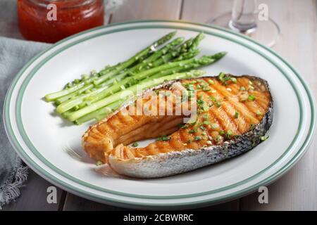 Lachssteak mit gedämpftem Spargel, rotem Kaviar und Schnittlauch Stockfoto