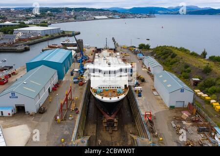 Greenock, Schottland, Großbritannien. 16. August 2020. Luftaufnahme der umstrittenen CalMac Fähre MV Glen Sannox in Dales Dry Dock in Greenock am Fluss Clyde.die teilweise gebaute Fähre, die weit über Budget und Jahre spät ist, Wurde diese Woche von der Ferguson Marine Werft in Port Glasgow zum nahe gelegenen Trockendock verlegt, um den Bug zu modifizieren, zu reparieren und zu reinigen. Iain Masterton/Alamy Live News Stockfoto