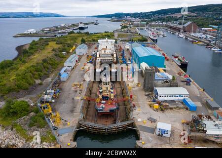 Greenock, Schottland, Großbritannien. 16. August 2020. Luftaufnahme der umstrittenen CalMac Fähre MV Glen Sannox in Dales Dry Dock in Greenock am Fluss Clyde.die teilweise gebaute Fähre, die weit über Budget und Jahre spät ist, Wurde diese Woche von der Ferguson Marine Werft in Port Glasgow zum nahe gelegenen Trockendock verlegt, um den Bug zu modifizieren, zu reparieren und zu reinigen. Iain Masterton/Alamy Live News Stockfoto