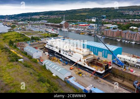 Greenock, Schottland, Großbritannien. 16. August 2020. Luftaufnahme der umstrittenen CalMac Fähre MV Glen Sannox in Dales Dry Dock in Greenock am Fluss Clyde.die teilweise gebaute Fähre, die weit über Budget und Jahre spät ist, Wurde diese Woche von der Ferguson Marine Werft in Port Glasgow zum nahe gelegenen Trockendock verlegt, um den Bug zu modifizieren, zu reparieren und zu reinigen. Iain Masterton/Alamy Live News Stockfoto