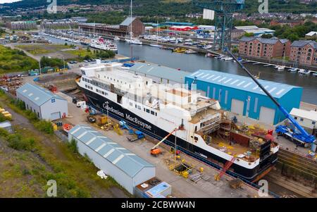 Greenock, Schottland, Großbritannien. 16. August 2020. Luftaufnahme der umstrittenen CalMac Fähre MV Glen Sannox in Dales Dry Dock in Greenock am Fluss Clyde.die teilweise gebaute Fähre, die weit über Budget und Jahre spät ist, Wurde diese Woche von der Ferguson Marine Werft in Port Glasgow zum nahe gelegenen Trockendock verlegt, um den Bug zu modifizieren, zu reparieren und zu reinigen. Iain Masterton/Alamy Live News Stockfoto