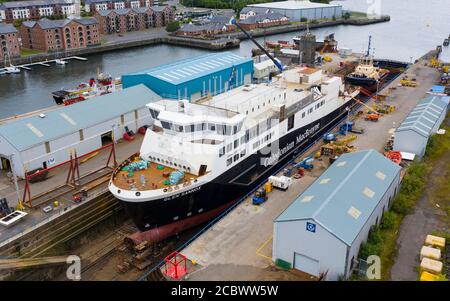 Greenock, Schottland, Großbritannien. 16. August 2020. Luftaufnahme der umstrittenen CalMac Fähre MV Glen Sannox in Dales Dry Dock in Greenock am Fluss Clyde.die teilweise gebaute Fähre, die weit über Budget und Jahre spät ist, Wurde diese Woche von der Ferguson Marine Werft in Port Glasgow zum nahe gelegenen Trockendock verlegt, um den Bug zu modifizieren, zu reparieren und zu reinigen. Iain Masterton/Alamy Live News Stockfoto