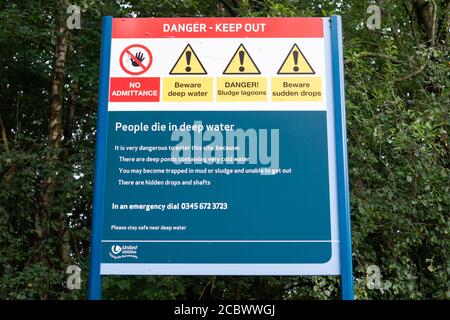 Schild mit verschiedenen Gefahrenhinweisen in der Nähe einer Wasseraufbereitungsanlage von United Utilities in der Red Rock Lane, Stoneclough, England, Großbritannien Stockfoto