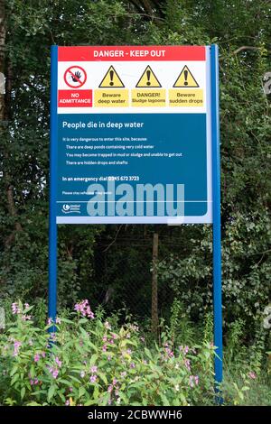 Schild mit verschiedenen Gefahrenhinweisen in der Nähe einer Wasseraufbereitungsanlage von United Utilities in der Red Rock Lane, Stoneclough, England, Großbritannien Stockfoto