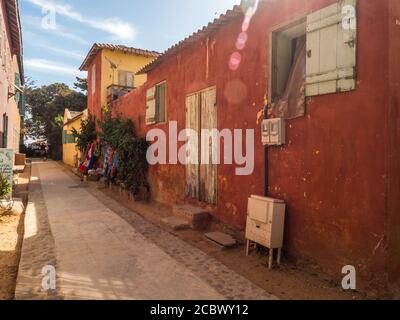 Goree, Senegal - Februar 2, 2019: Alltag und Straße mit Kopfsteinpflaster Straße zwischen Bunte Häuser auf der Insel Goree. Gorée. Dakar, Seneg Stockfoto