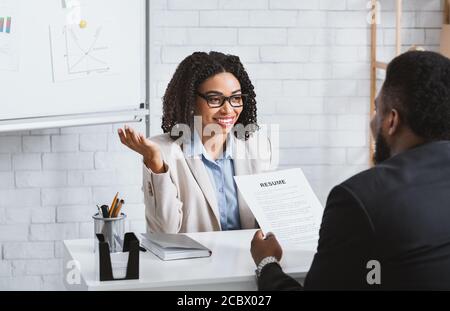 Freundliche Personalmanager interviewt schwarzen Kandidaten während des Vorstellungsgesprächs bei Modernes Büro Stockfoto
