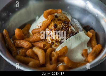 Nahaufnahme von geschältem Eis weichen Tofu mit Ingwersirup mit frittierten Teigstäbchen (pa tang ko) in Silber Schüssel gekrönt. Gut für die Gesundheit. Selektiver Fokus. Stockfoto