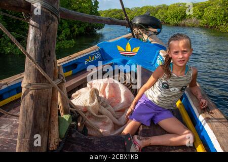 Europäische Touristen Mädchen in einer Dhow Segeln durch Makanda Kanal, Lamu Archipel, Kenia. Rote Mangroven entlang der Küste von Manda Island Stockfoto