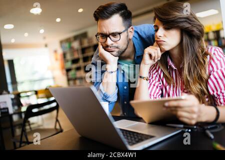 Hochschulkonzept, Studium, Hochschule und Bildungskonzept. Gruppe von müden Schülern, die in der Bibliothek lernen Stockfoto