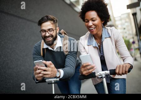 Junges Paar im Urlaub, das Spaß hat, mit dem Elektroscooter durch die Stadt zu fahren. Stockfoto