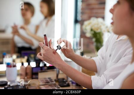 Nahaufnahme der Hand eines professionellen Make-up-Künstlers mit Lippenstift Studenten im Meisterkurs Stockfoto