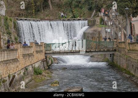 Touristen besuchen den künstlichen Wasserfall auf dem Fluss Psyrzkha. Abchasien Stockfoto