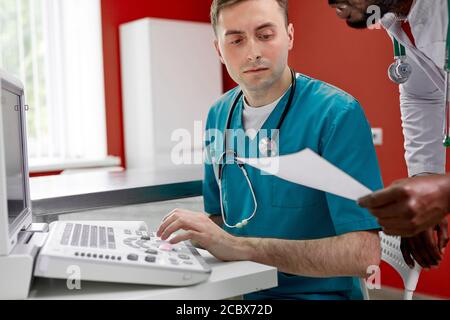 Tierarzt Arzt und Assistent besprechen PET Pathologie mit speziellen Monitor-Ausrüstung in der Klinik, führen medizinische Untersuchung von Tier Stockfoto