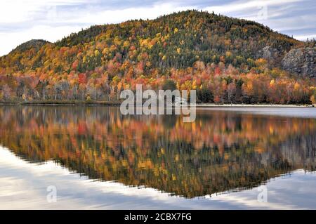 Später Herbstnachmittag im Franconia Notch State Park in New Hampshire. Farbenfrohe Herbstfärbung, die sich auf der ruhigen Oberfläche des Echo Lake widerspiegelt. Künstler Bluff, Witz Stockfoto