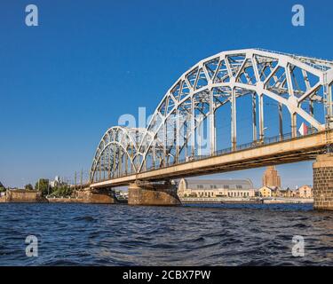 Die Eisenbahnbrücke, die den Daugava-Fluss in Riga, der Hauptstadt Lettlands, überquert. Stockfoto