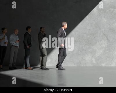 Gruppe von Geschäftsleuten kommen aus den Schatten Stockfoto
