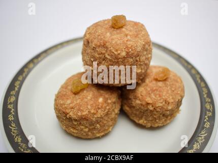 Nahaufnahme von beliebten indischen süßen Kugeln Laddu oder ladoo aus Chapati roti gepudert pushed und in großen Ball gemacht. Dekoriert mit Rosinenkismis Serv Stockfoto