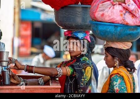 Nashik, Maharashtra/Indien - 15. Oktober 2009: Stammesfrauen trinken Wasser aus einem öffentlichen Brunnen in Nashik, Maharashtra. Stockfoto