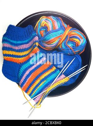 Wolle gestrickte Socke, Garn und Stricknadeln auf weißem Hintergrund Stockfoto