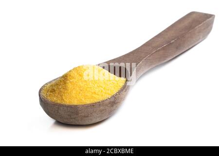 Maiskörner polenta in Holzlöffel isoliert auf weiß Stockfoto